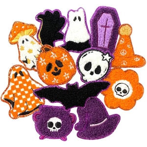Könnte beinhalten: Ein Set mit 11 Halloween-Filzpatches. Die Patches zeigen verschiedene Halloween-Symbole, darunter ein Geist, ein Kürbis, eine Fledermaus, ein Schädel, ein Hexenhut und ein Sarg. Die Patches sind alle in verschiedenen Farbtönen von Orange, Lila, Schwarz und Weiß.