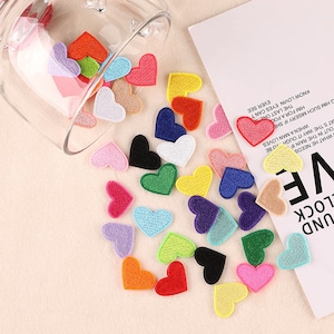 May include: Assortment of colorful felt heart patches. The patches are in various shades of red, pink, blue, green, yellow, orange, and purple.