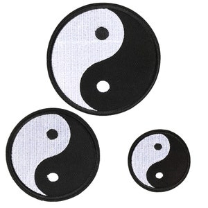 May include: Three black and white embroidered yin yang patches of different sizes. The patches are circular and feature the traditional yin yang symbol with a white dot in the black half and a black dot in the white half.