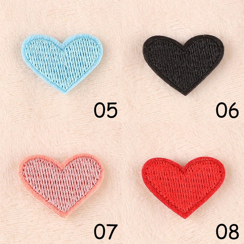 May include: Four heart-shaped fabric patches in different colors: light blue, black, pink, and red. The patches are numbered 05, 06, 07, and 08.