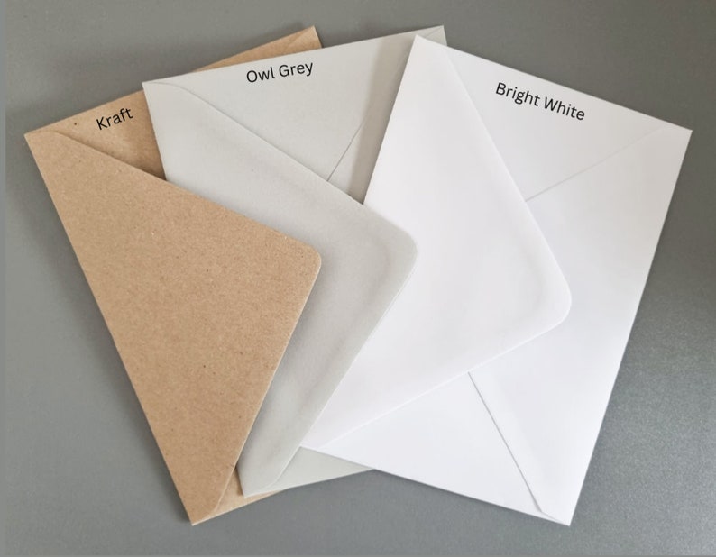 K&ouml;nnte beinhalten: Eine Auswahl an Umschl&auml;gen in den Farben Kraft, Eulen-Grau und Hellwei&szlig;. Die Umschl&auml;ge sind geschichtet und zeigen ihre verschiedenen Farbt&ouml;ne und Texturen. Die Farbbezeichnungen sind aufgedruckt.