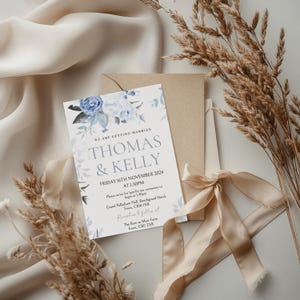 May include: A wedding invitation with blue floral designs. The invitation reads "We are getting married, Thomas & Kelly, Friday 16th November 2024 at 1:30pm. Please arrive for 1:30pm for our ceremony to begin at 1:30pm. Grand Palladium Hall, Beechgrand Hotel, Essex, CB10 1XB. Reception to follow at The Barn at Mew Farm, Essex, CB11 2XB."