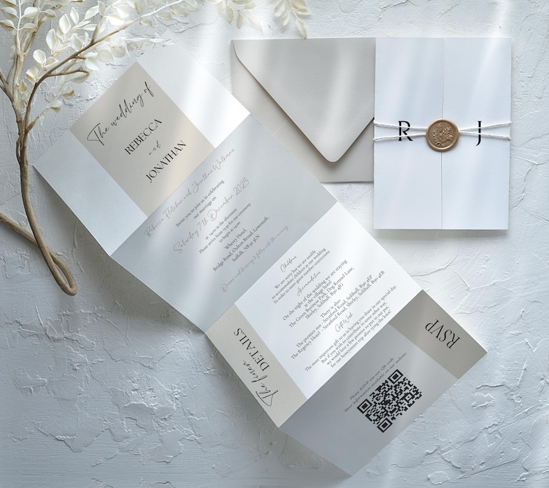 K&ouml;nnte beinhalten: Elegante Hochzeitseinladungssuite in Wei&szlig;- und Beiget&ouml;nen. Die gefaltete Einladung zeigt den Text &bdquo;The wedding of Rebecca and Jonathan&ldquo; und enth&auml;lt Details, RSVP und einen QR-Code. Ein passender Umschlag und eine versiegelte Einladung sind ebenfalls enthalten.