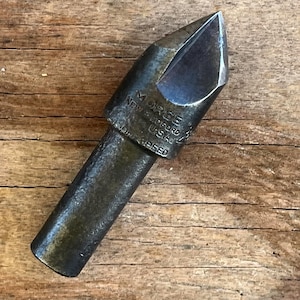 May include: A vintage Morse New Bedford USA high-speed drill bit. The metal tool has a dark, aged appearance with a sharp, angled tip. The text "MORSE NEW BEDFORD USA SPEED" is visible on the tool.