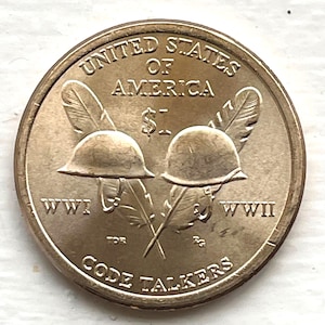 May include: A United States of America dollar coin featuring two World War I and World War II helmets, crossed feathers, and the text "CODE TALKERS". The coin has the text "UNITED STATES OF AMERICA" and "$1".