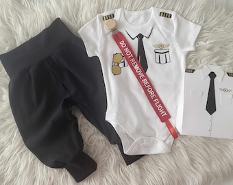 Body de vestir de piloto para bebé - Disponible en tallas 0-3 meses - 2 años - Joggers o pantalones cortos negros a juego, clip para chupete y caja de regalo disponibles