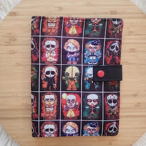 May include: A black zippered pouch with a colourful pattern of horror movie characters. The pouch has a black strap with a red button.