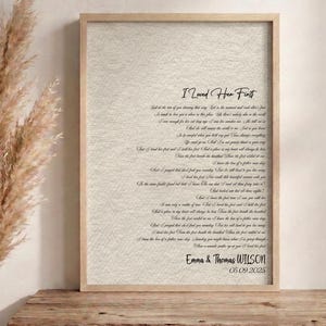 May include: A framed vertical print on a textured beige background featuring the song lyrics to I Loved Her First in black script and serif fonts, personalized with the names Emma & Thomas Wilson and the date 05 09 2025 at the bottom.