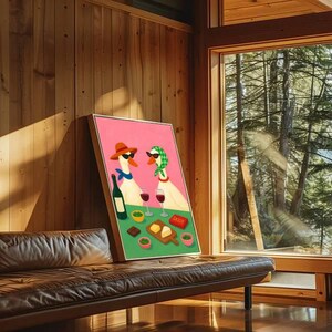 May include: A framed art print featuring two geese wearing sunglasses and hats, enjoying wine and snacks. The artwork has a pink background and a green foreground with the word "Sassy" on a small red sign. The print is leaning against a wooden wall.