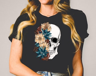 May include: Black t-shirt with a white skull graphic. The skull is half covered with colorful flowers, including blue, yellow, and brown.