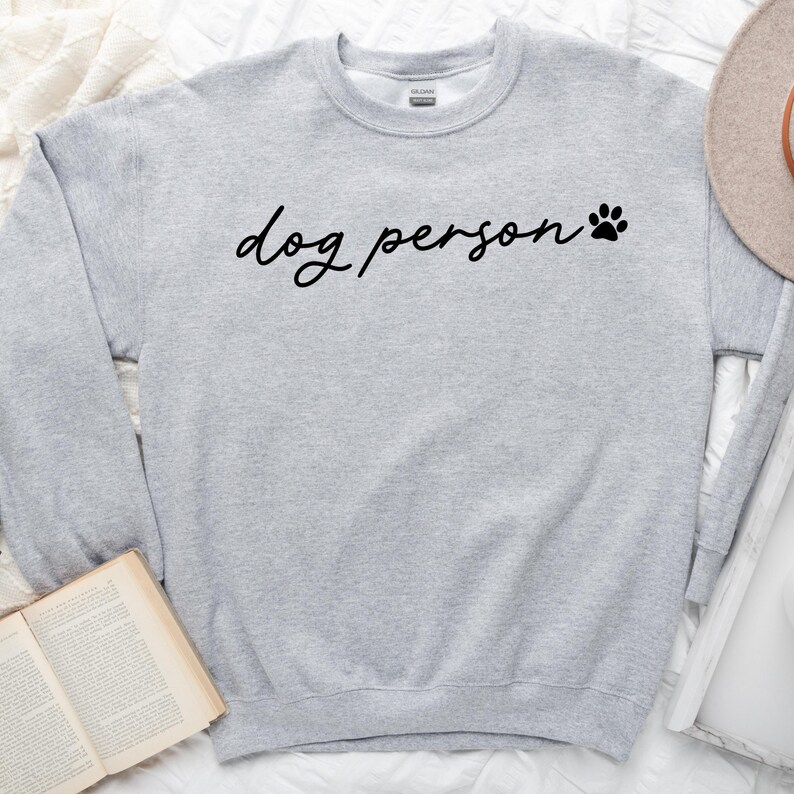 May include: Gray sweatshirt with the text "dog person" and a paw print in black.