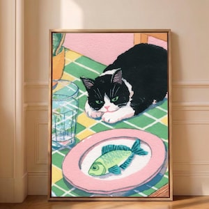 May include: A framed illustration of a black and white cat resting on a green and white checkered tablecloth next to a clear glass of water and a pink plate containing a single green fish. The scene is set against a soft pink wall background.