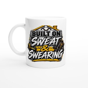 Könnte beinhalten: Ein weißer Keramikbecher mit einem grafischen Design, das den Umriss eines Hauses mit zwei gekreuzten Hämmern zeigt. Der Text BUILT ON SWEAT & SWEARING ist in fetten schwarz-weißen Buchstaben gedruckt, ergänzt durch Abbildungen von Werkzeugen.