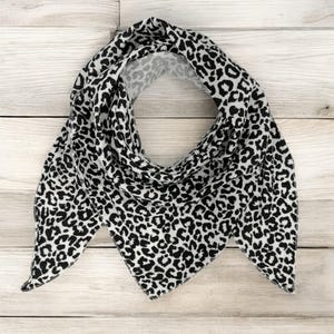 May include: A black and white leopard print bandana with a triangular shape.