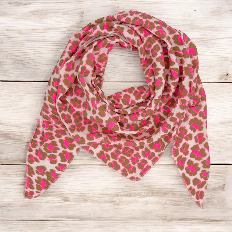 May include: A pink and brown leopard print scarf. The scarf is made of a soft, lightweight fabric and is perfect for adding a touch of style to any outfit.