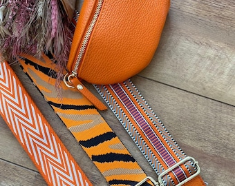 Puede incluir: Tres correas de patrón naranja y blanco con hebillas doradas y una pequeña bolsa de cuero naranja. Las correas son para un bolso o una cartera.