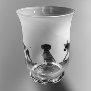 Könnte beinhalten: Eine gefrostete Glasvase mit einer Silhouette von drei Hunden, die in die Seite graviert sind. Die Vase ist aus klarem Glas mit einer matten Oberfläche und einem runden Boden.