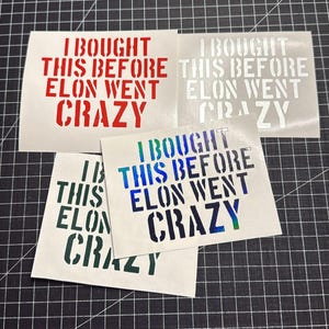 May include: Three white vinyl stickers with the text "I bought this before Elon went crazy" in red, white, and blue lettering.