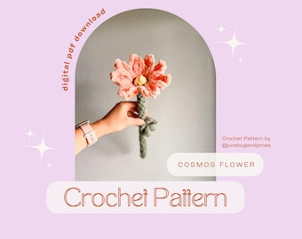 May include: A crochet cosmos flower with peach petals and a yellow center, held by a hand. The stem is green, and the background is a light purple with text that says "Crochet Pattern" and "Cosmos Flower".