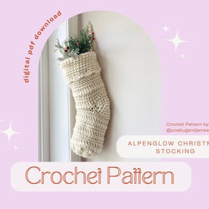 May include: A crochet pattern for an Alpenglow Christmas Stocking. The pattern is by @junebugandjames. The stocking is white and has a crocheted design. It is decorated with a sprig of greenery and red berries.