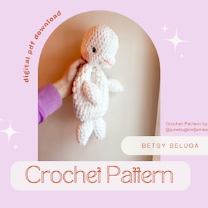 May include: A crocheted white amigurumi beluga whale toy named Betsy. The toy is being held by a hand wearing a purple shirt. The text "Crochet Pattern" is in the lower part of the image. The text "Betsy Beluga" is in the upper part of the image. The text "Crochet Pattern by @junebugandjames" is in the lower right corner of the image.