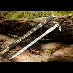 May include: A black and gold sword with a black scabbard. The scabbard has a gold design with a triangular pattern. The sword is on a wooden surface.