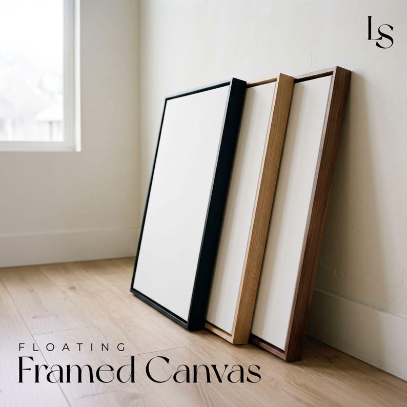 three floating framed canvases of different wood finishes, including black, light brown, and white, arranged on a wooden floor against a white wall.