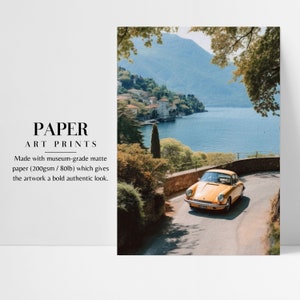 a yellow car driving down a road next to a lake