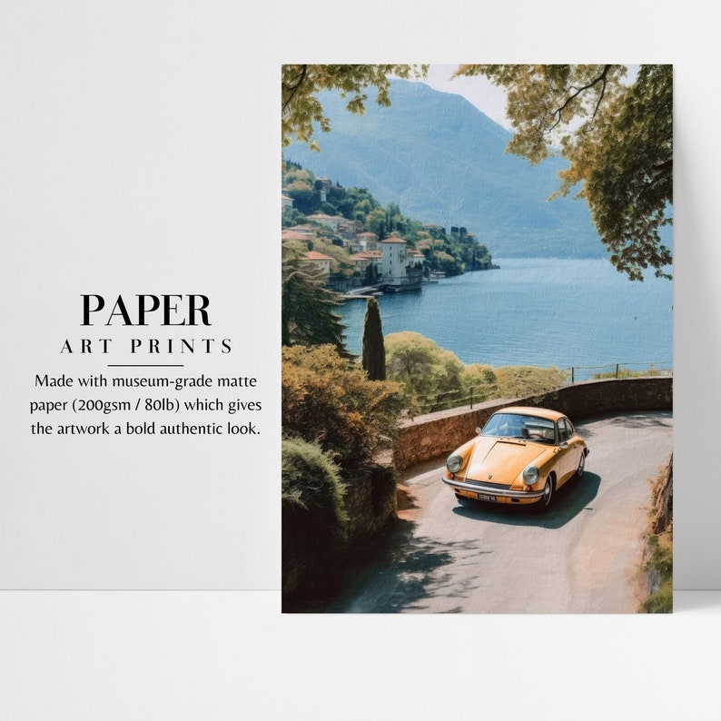 a yellow car driving down a road next to a lake