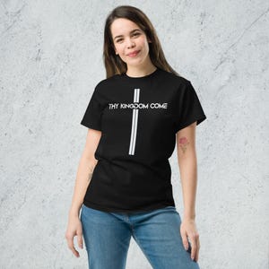 May include: Black t-shirt with the text "THY KINGDOM COME" above a white cross design. The cross is formed by two vertical white lines. The shirt is made of a soft material and is suitable for casual wear.