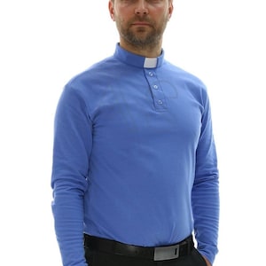 Może przedstawiać: Koszula z długim rękawem w jasnoniebieskim kolorze z białym kołnierzykiem i zapinaniem na guziki. Koszula ma klasyczny krój i jest wykonana z miękkiej, wygodnej tkaniny.