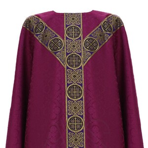 May include: A purple liturgical vestment with a gold and purple trim featuring a repeating pattern of crosses and floral designs.