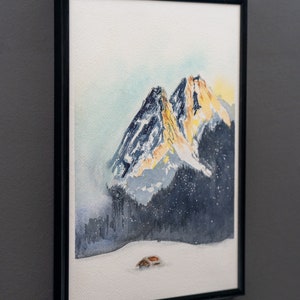 Watercolor painting of the sun setting behind the Garmisch-Partenkirchen mountains, featuring vibrant orange peaks against a darkening blue sky, with a small cabin in the snowy foreground.