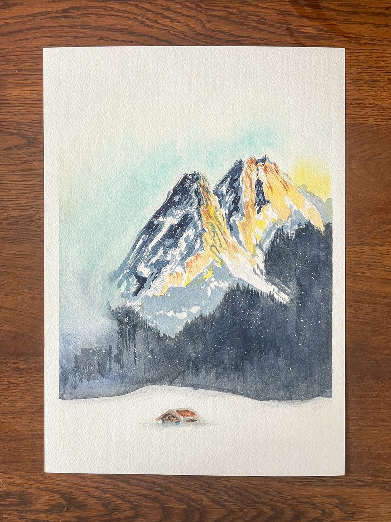 Watercolor painting of the sun setting behind the Garmisch-Partenkirchen mountains, featuring vibrant orange peaks against a darkening blue sky, with a small cabin in the snowy foreground.