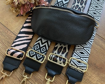 Puede incluir: Cinco correas de tela con diferentes patrones, con extremos de cuero negro y cierres dorados. Las correas son para un bolso o una cartera.