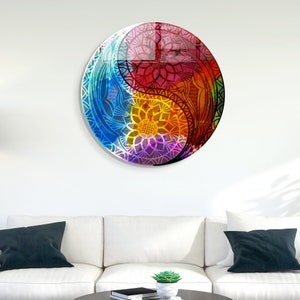 May include: A colorful mandala design in the shape of a yin yang symbol. The mandala is made up of intricate patterns in shades of blue, red, yellow, and purple.