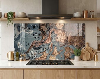 May include: A rectangular kitchen backsplash panel featuring a swirling abstract pattern of metallic copper, slate blue, and black tones. The surface has a glossy finish and is positioned behind a black gas stovetop on a white marble countertop.