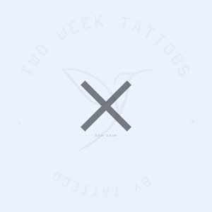 Puede incluir: Un tatuaje en forma de X gris, de 0,9 pulgadas o 2,4 centímetros de tamaño, con el texto "TWO WEEK TATTOOS BY TATTEO" alrededor de la imagen.