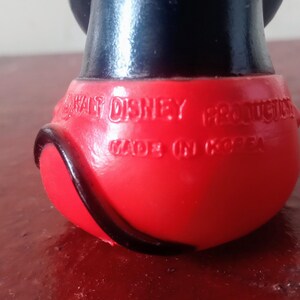 May include: Red and black plastic Mickey Mouse figurine with the text "Walt Disney Productions Made in Korea" on the bottom.