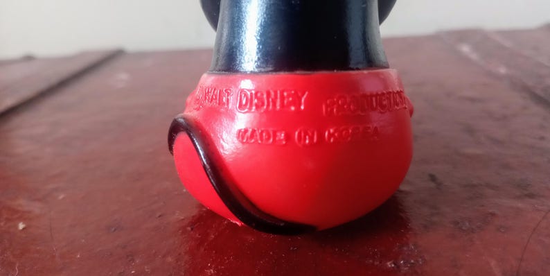May include: Red and black plastic Mickey Mouse figurine with the text "Walt Disney Productions Made in Korea" on the bottom.