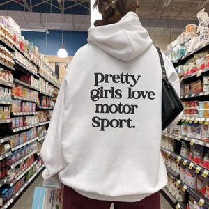 May include: White hooded sweatshirt with the text "pretty girls love motor sport." printed on the back.