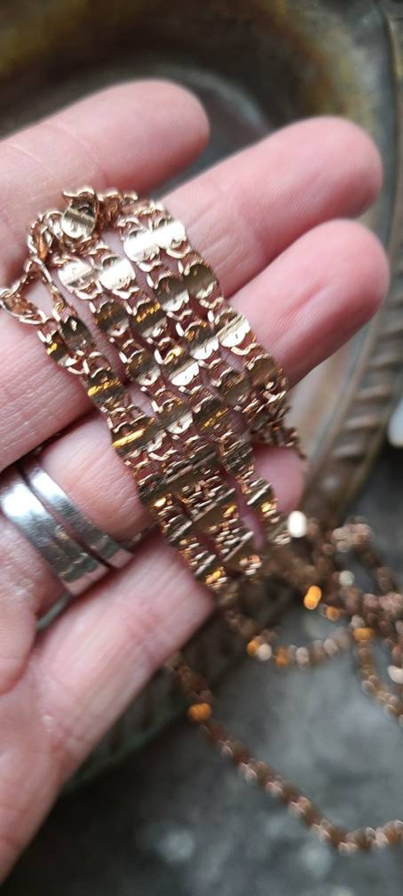 Puede incluir: Primer plano de un collar de cadena de oro con un dise&ntilde;o delicado e intrincado. La cadena est&aacute; en capas y parece estar hecha de m&uacute;ltiples hebras.