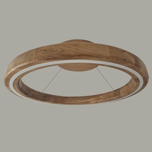 Op de afbeelding: Een ronde houten plafondlamp met een witte LED-ring rondom de omtrek.