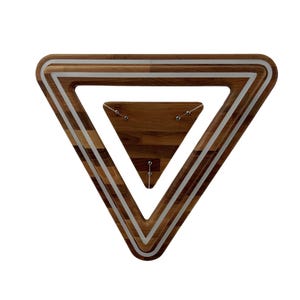 May include: A wooden triangular wall decor with a silver trim. The triangle is layered with a smaller triangle inside.