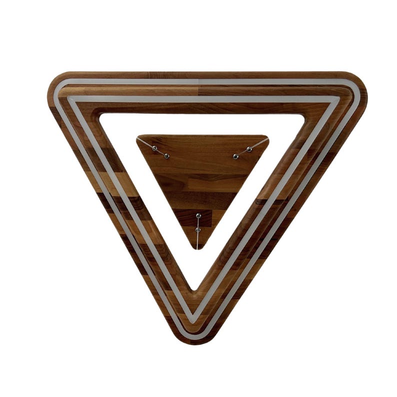 May include: A wooden triangular wall decor with a silver trim. The triangle is layered with a smaller triangle inside.