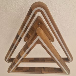May include: A wooden triangle pendant light with a white LED strip around the perimeter. The light is made of three stacked triangles, each with a different wood grain pattern.