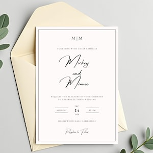 Puede incluir: Una invitación de boda con los nombres "Mickey y Minnie" en escritura cursiva. La tarjeta blanca está dentro de un sobre crema. La fecha es el 14 de diciembre de 2024 a las 14:00 horas.