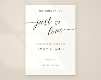 Könnte beinhalten: Ein weißes Hochzeit-Willkommensschild mit schwarzem Text, der NOTHING FANCY just love mit einem kleinen Herzsymbol zeigt, gefolgt von WELCOME TO THE WEDDING OF EMILY & JAMES, dem Datum 17. JULI 2027 und dem Ort LONDON, ENGLAND.