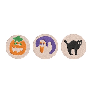 Może przedstawiać: Trzy okrągłe łatki z tkaniny z motywami Halloween. Pierwsza łatka przedstawia dynię z zieloną łodygą i pomarańczową twarzą. Druga łatka przedstawia fioletowego ducha z białą twarzą. Trzecia łatka przedstawia czarnego kota z białymi oczami.