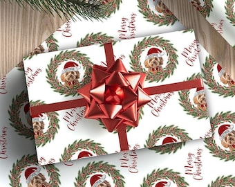 May include: White wrapping paper with a repeating pattern of a dog wearing a Santa hat in a Christmas wreath with the text "Merry Christmas".